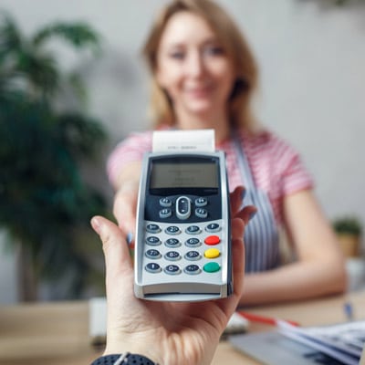 Man holding an EFT POS machine at a counter